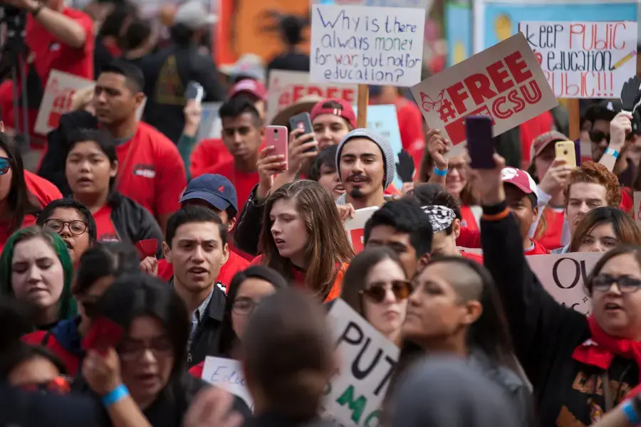 CFA members and CSU students carry signs advocating for funding for higher education.