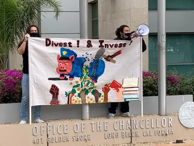 Members of Students for Quality Education protest outisde the Board meeting, demanded that Trustees divest from militarized campus police forces and re-invest student tuition for student spaces and resource centers. 