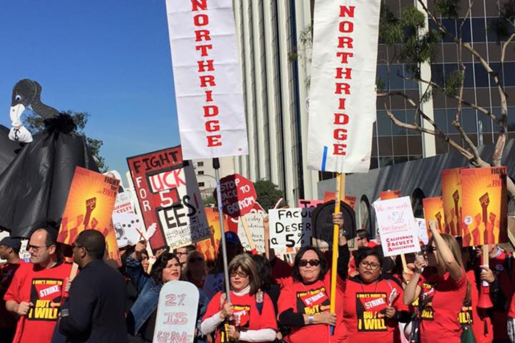 Large group of people wearing red shirts hold rally signs and white banners that read CFA Northridge.