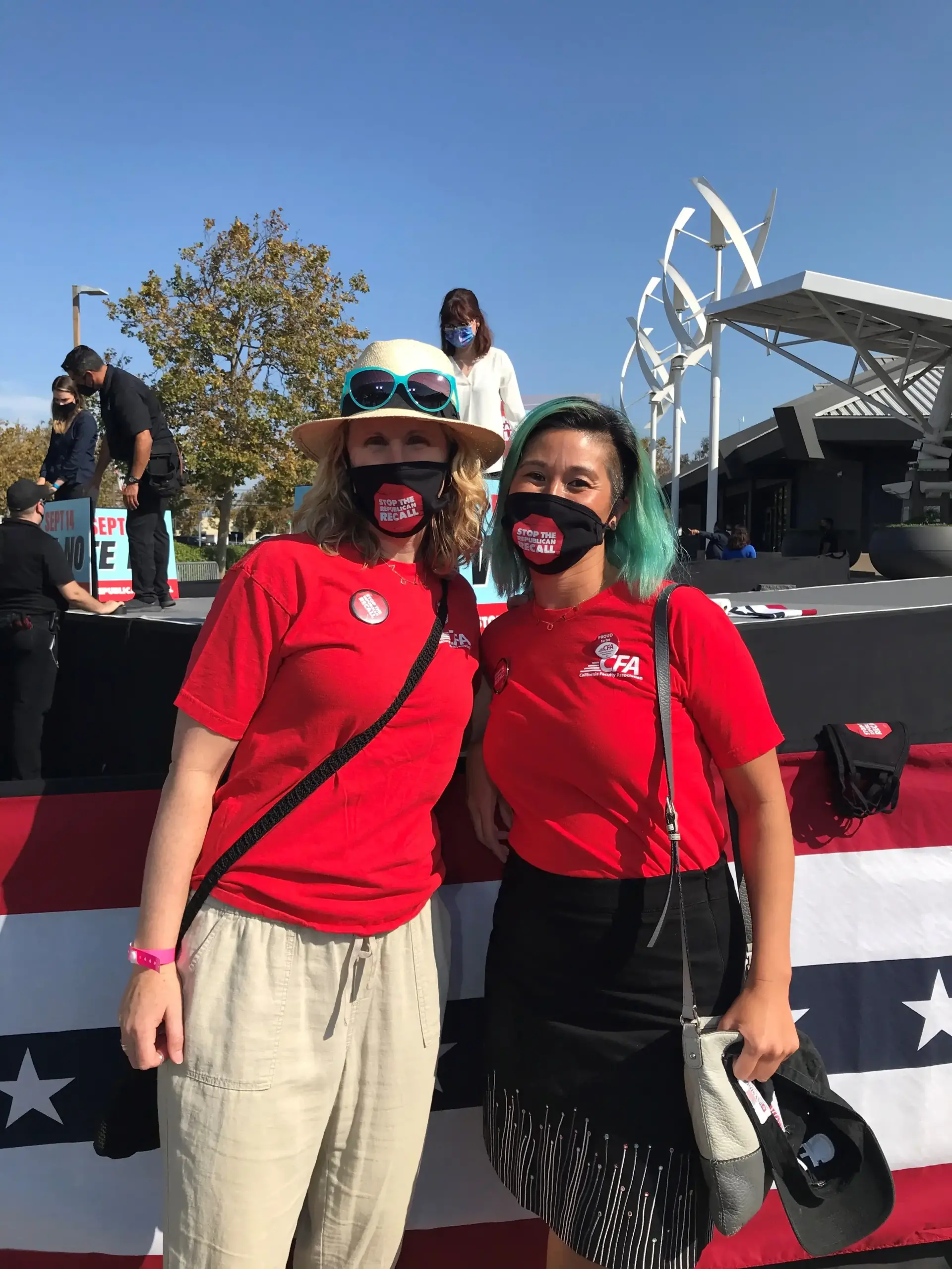 CFA East Bay members Amy Below and Danvy Le attend attend a No on the Recall rally in their red CFA shirts and anti-recall black and red face masks.