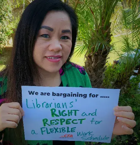 CFA member and treasurer holding a sign pushing for Rights, Respect, and Justice for librarians