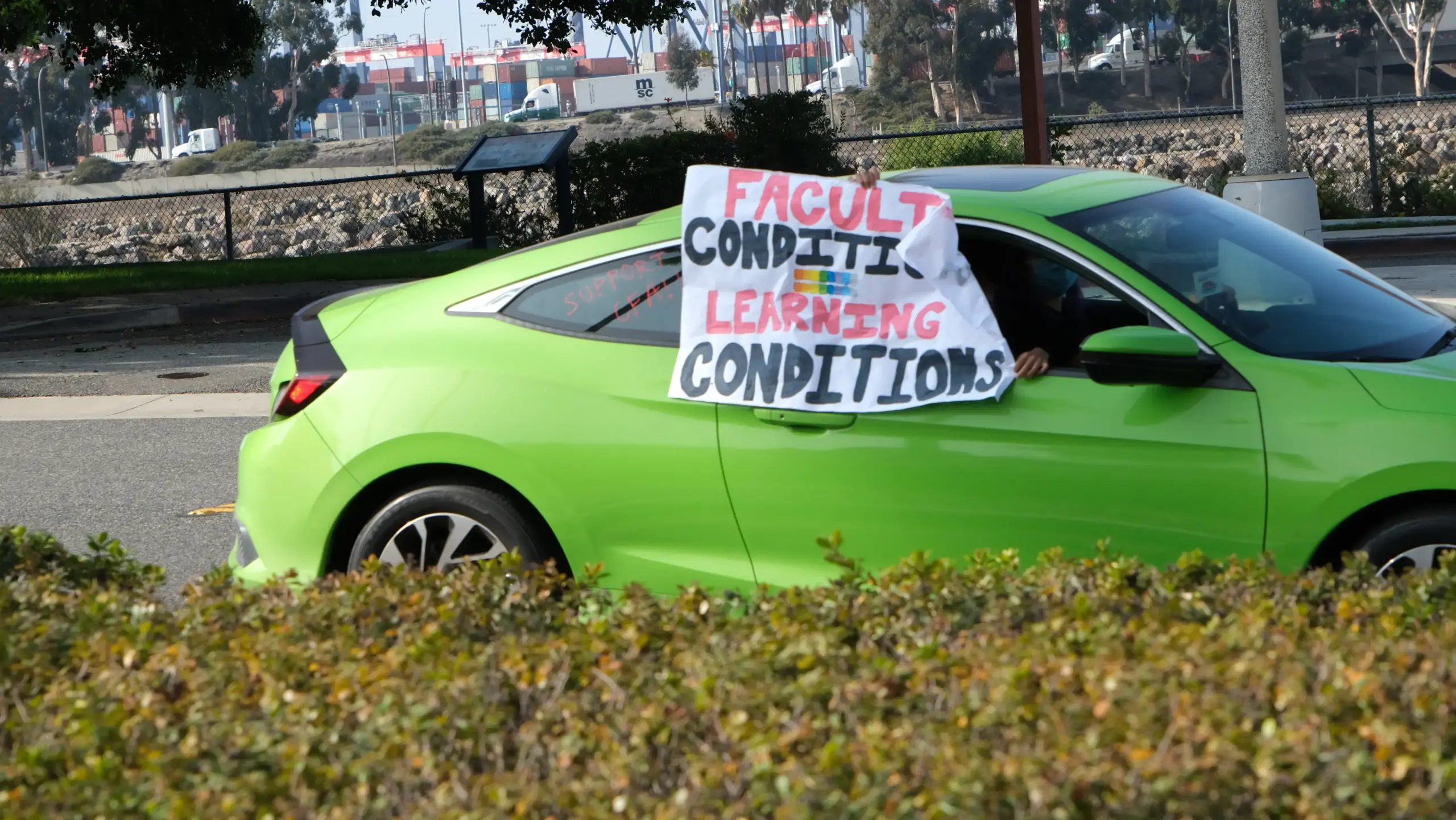 A green car with a sign on it