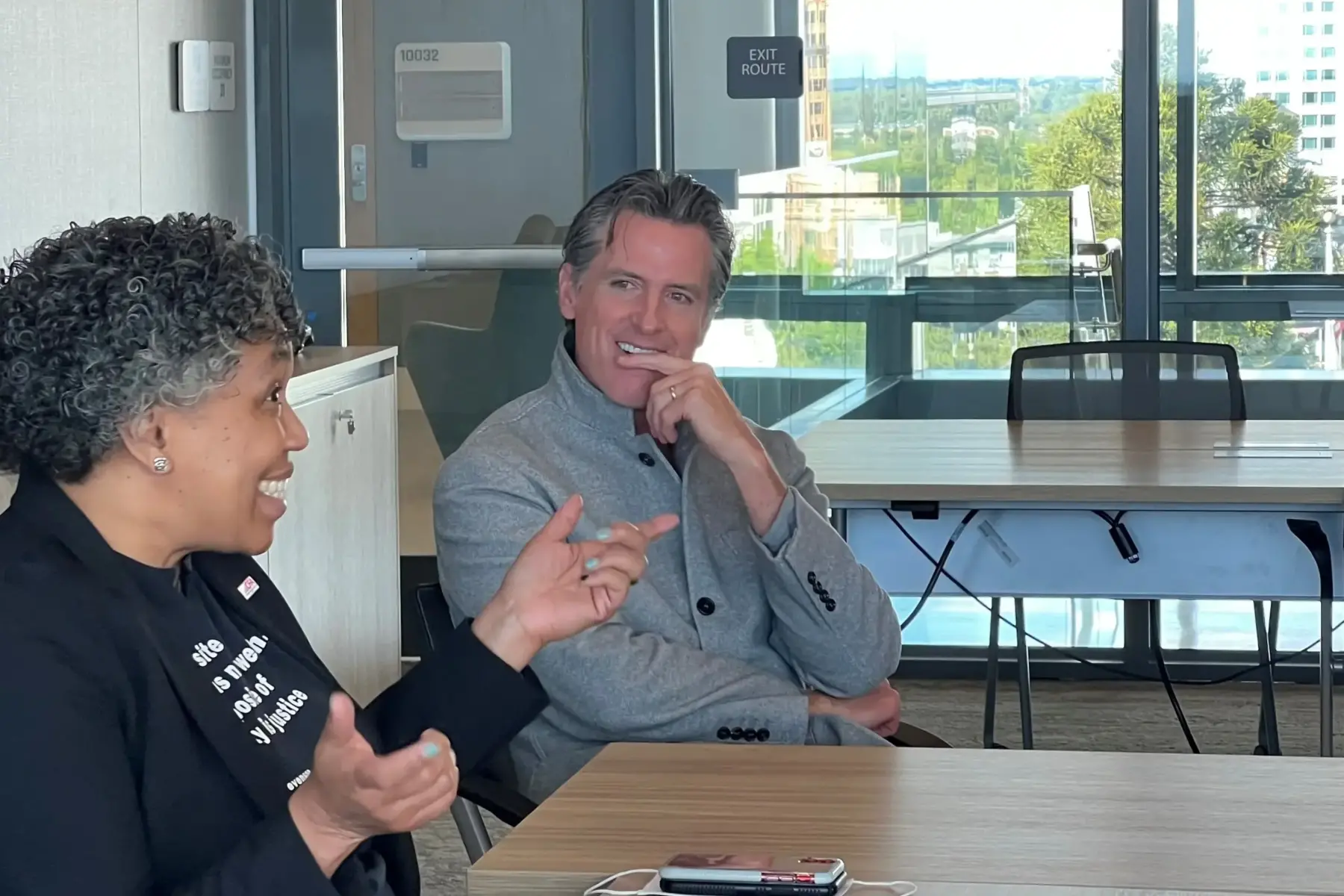 Two people talk in a meeting room.