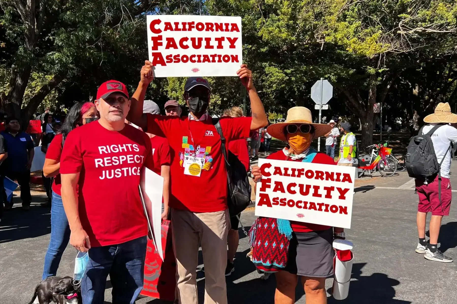 3 people holding up a sign