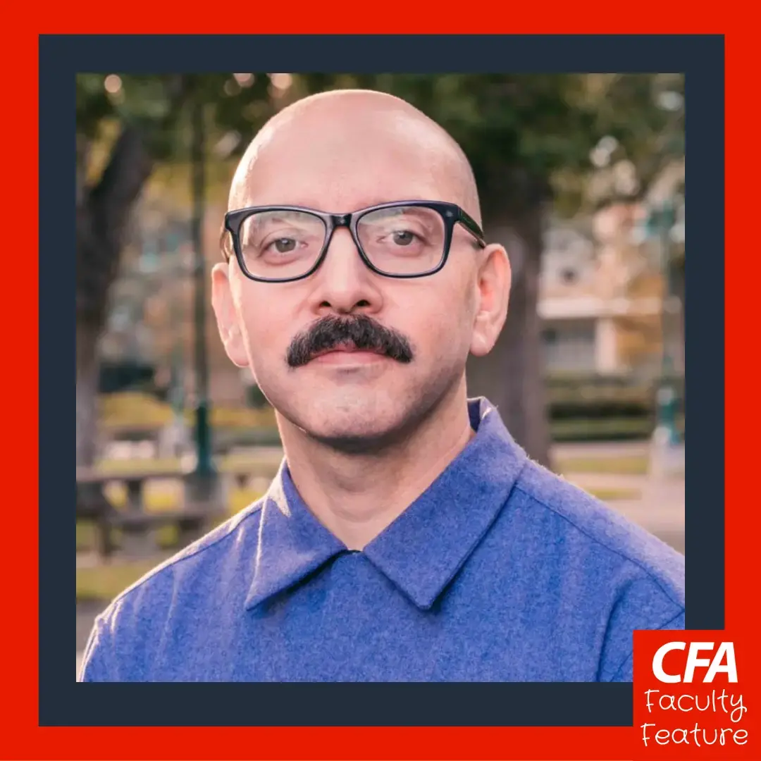 A man with glasses, blue collared tshirt in a photo.