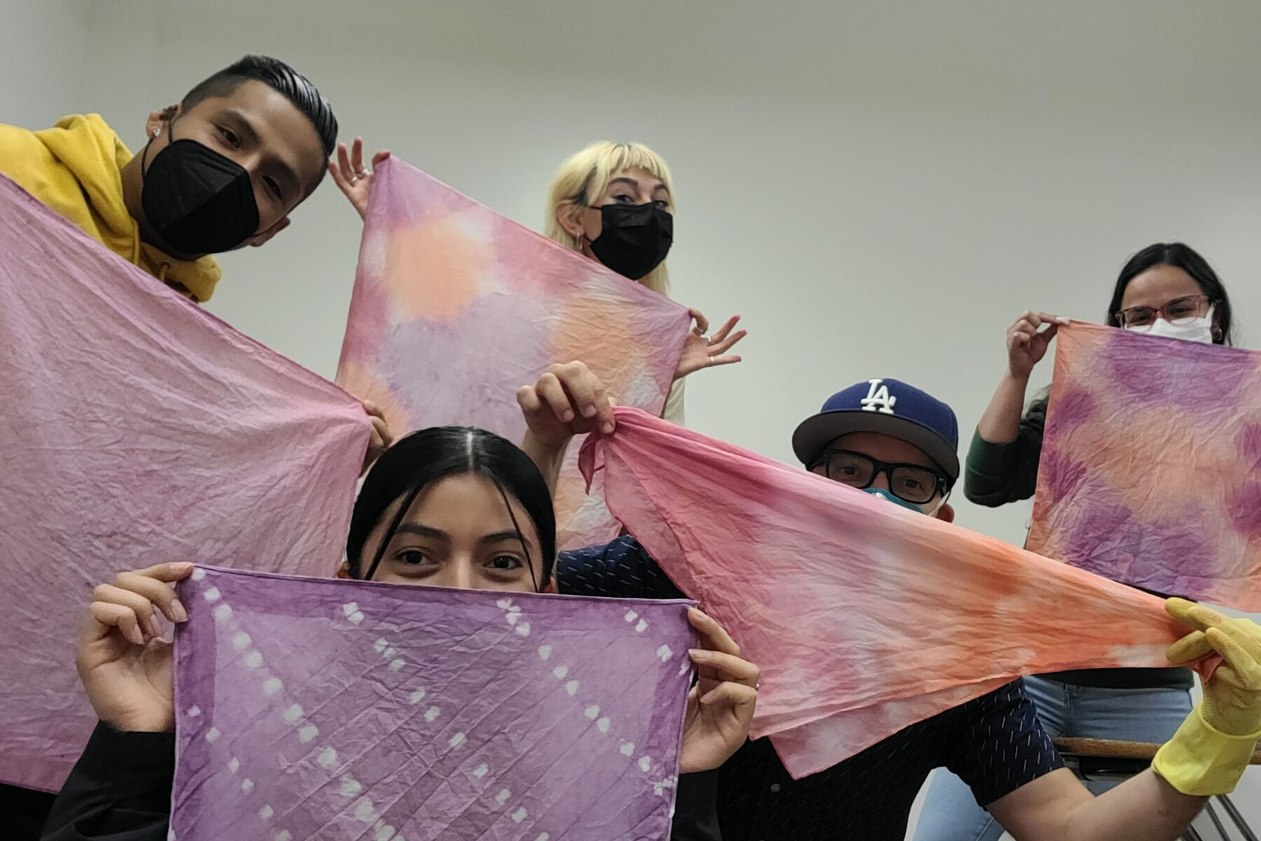 5 students holding up scarves