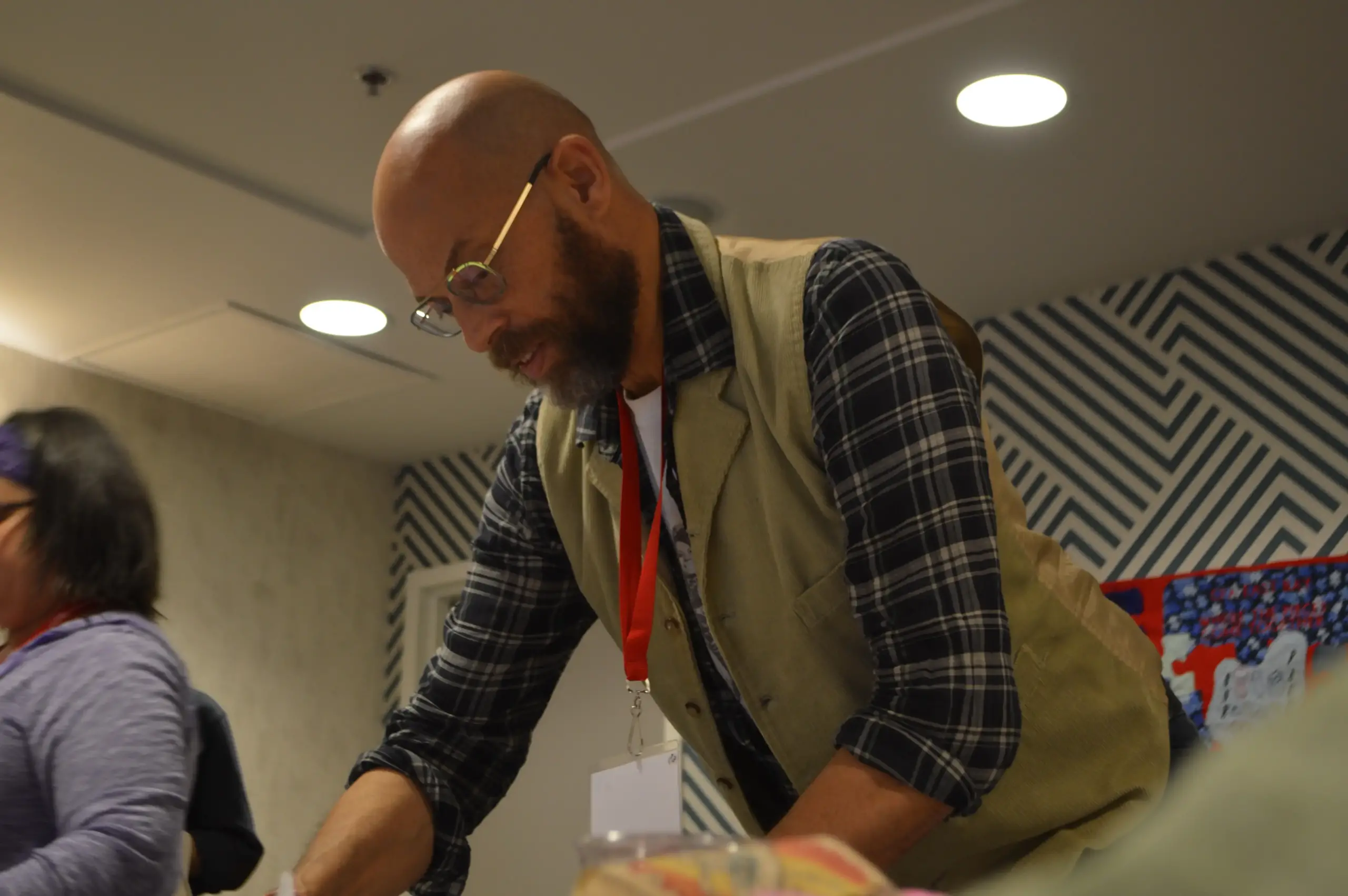 A man in glasses completing a project on a table.