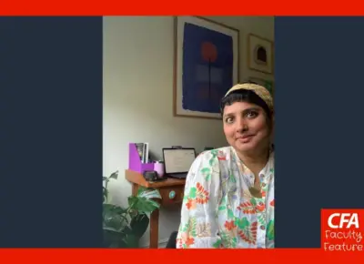 Woman in a floral cbouse poses for a candid photo in here home.
