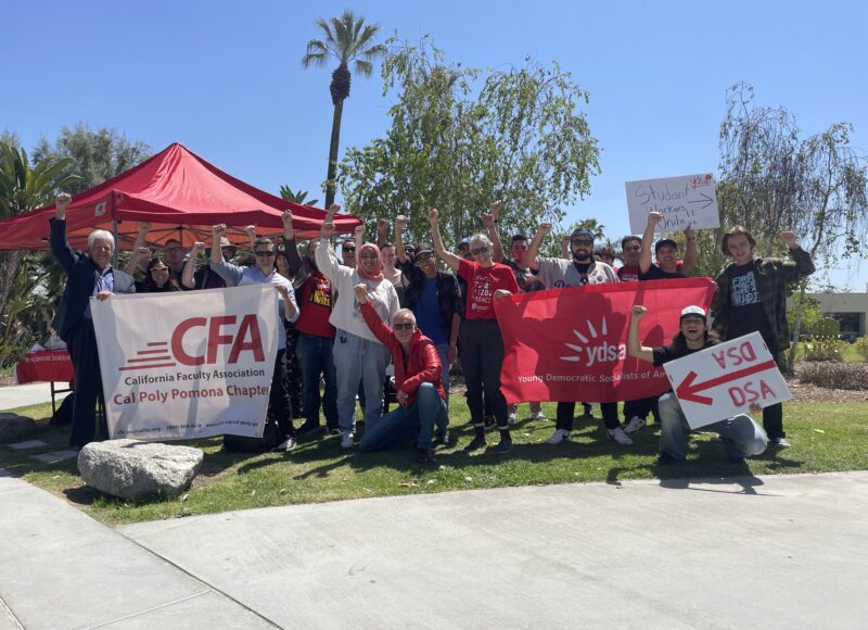 Group of people with banners and signs outdoors