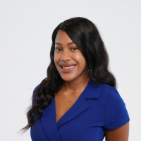 woman in a blue dress and black hair poses for a photo