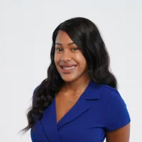 woman in a blue dress and black hair poses for a photo