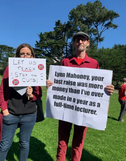 Two people with signs standing outdoors.