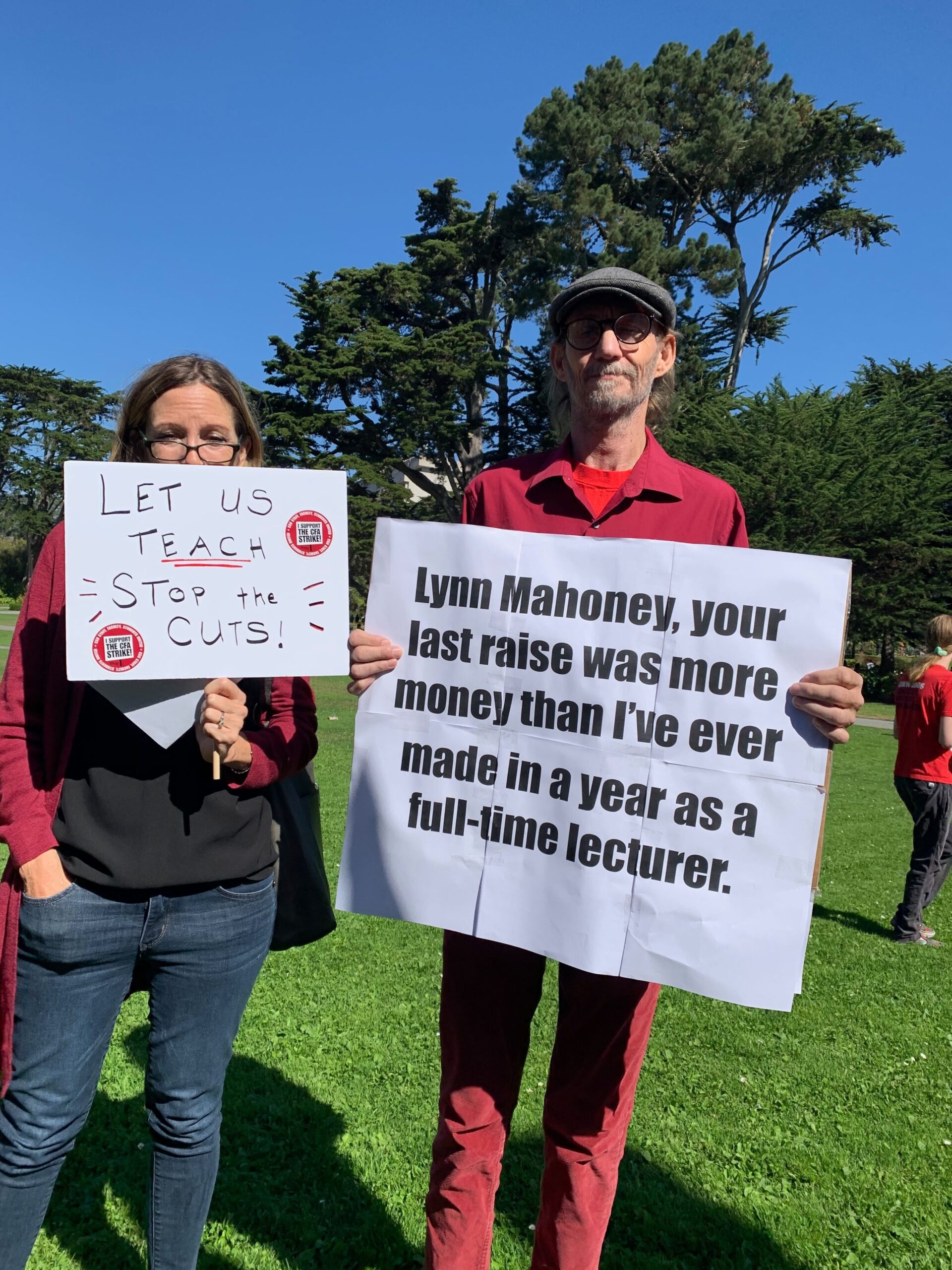 Two people with signs standing outdoors.