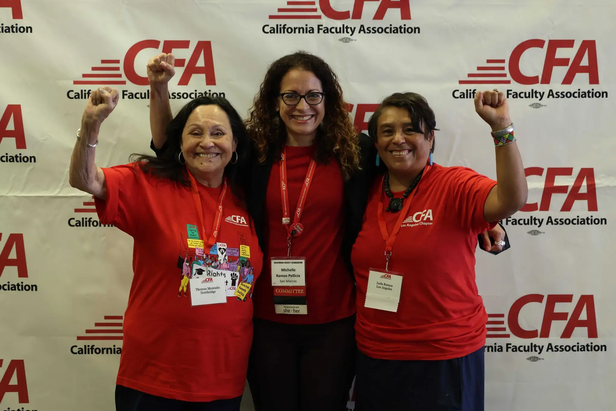 A group of women in red shirts pose for a photo infront of CFA banner.