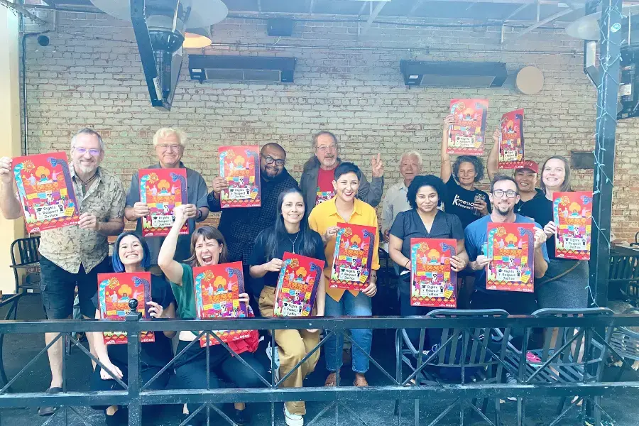 A group of people outside a building holding red CFA posters.