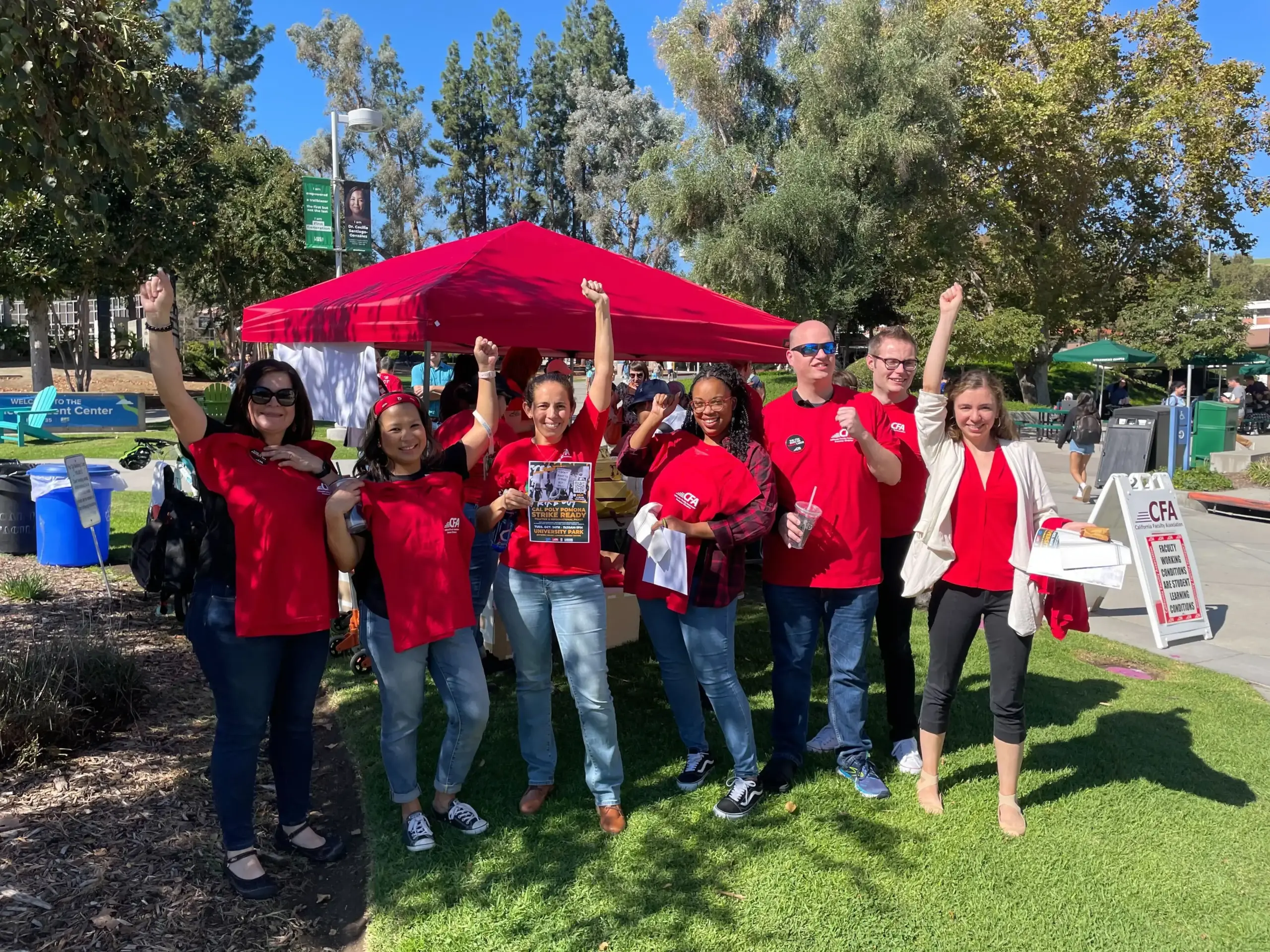 A group of people holding up fists a tabling event in Pamona.