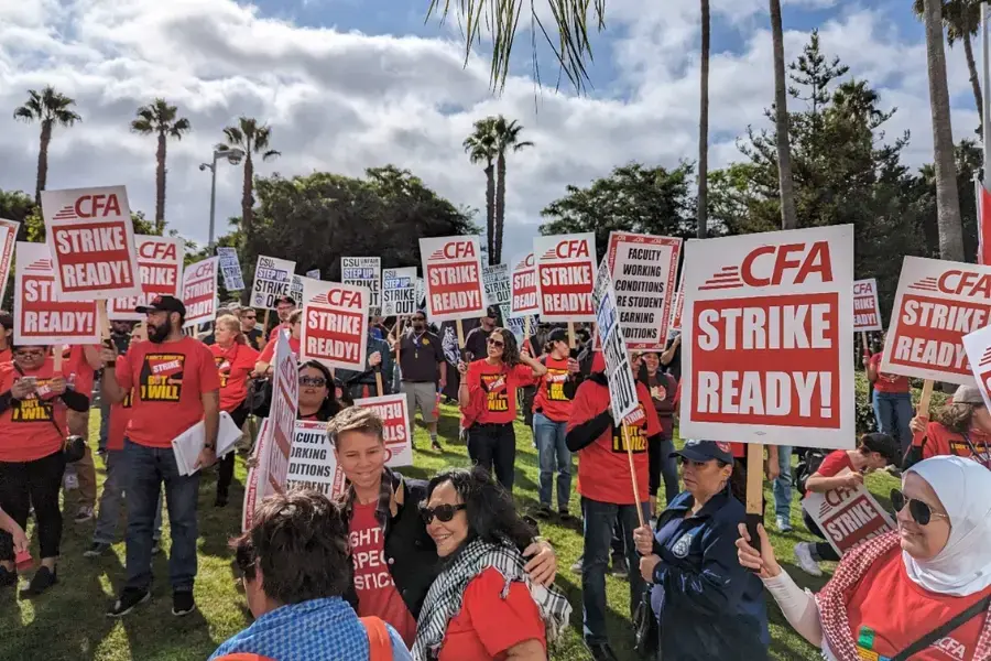 A large number of people hold up signs that read 'Strike Ready.'