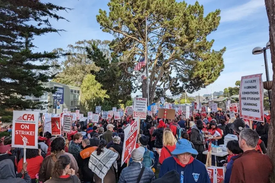 A large crowd gathers together in San Francisco with picket signs.