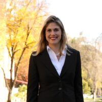 Candidate in business suit outdoors in front of capitol building.