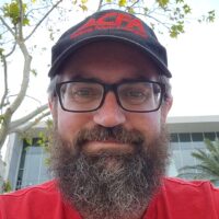 A man with a beard in a red CFA shirt and black cap with CFA logo