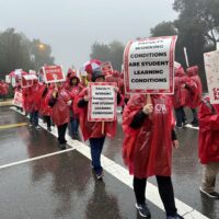 People marching in the rain wih signs