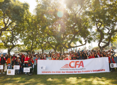A big group of people outdoors with banners and signs.