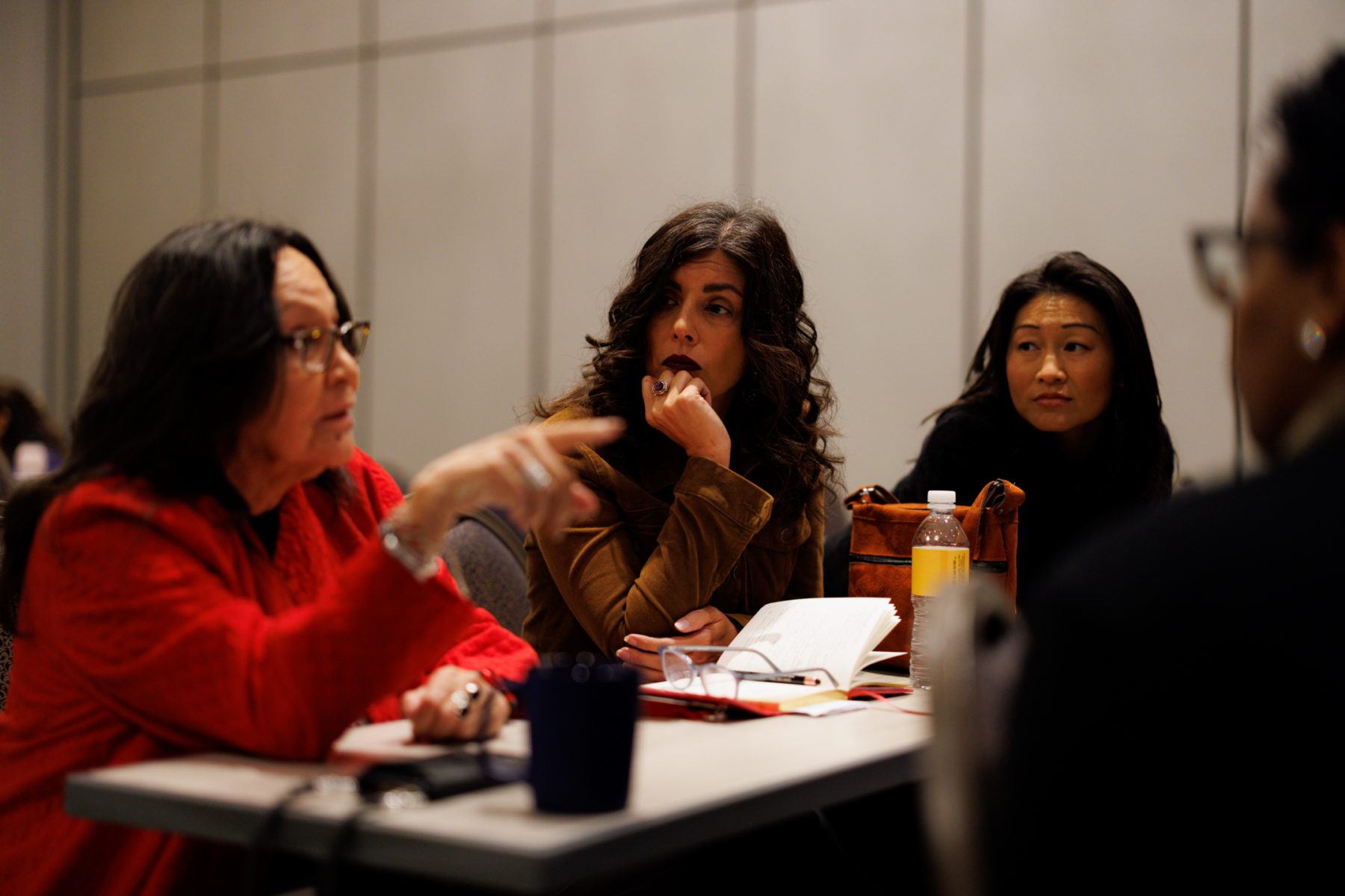 three cfa members discuss at a table