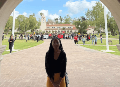 Student Angelmarie stands in an archway of a building