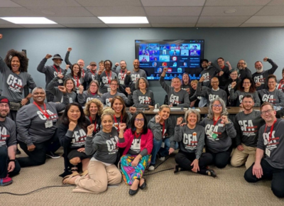 Group of people in bargaining shirts pose for a photo.