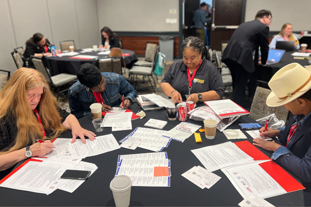 A group of folks at a table writing postcards to nonmembers asking them to join CFA.