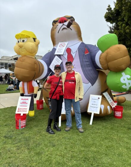 Solina Lindahl and Craig Flanery in front of "Fat Cat," and inflatable greedy cat.