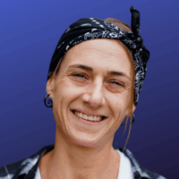 person smiles for a photo, wearing a black bandana on their head