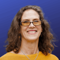 woman with brown hair in glasses and in a yellow sweater