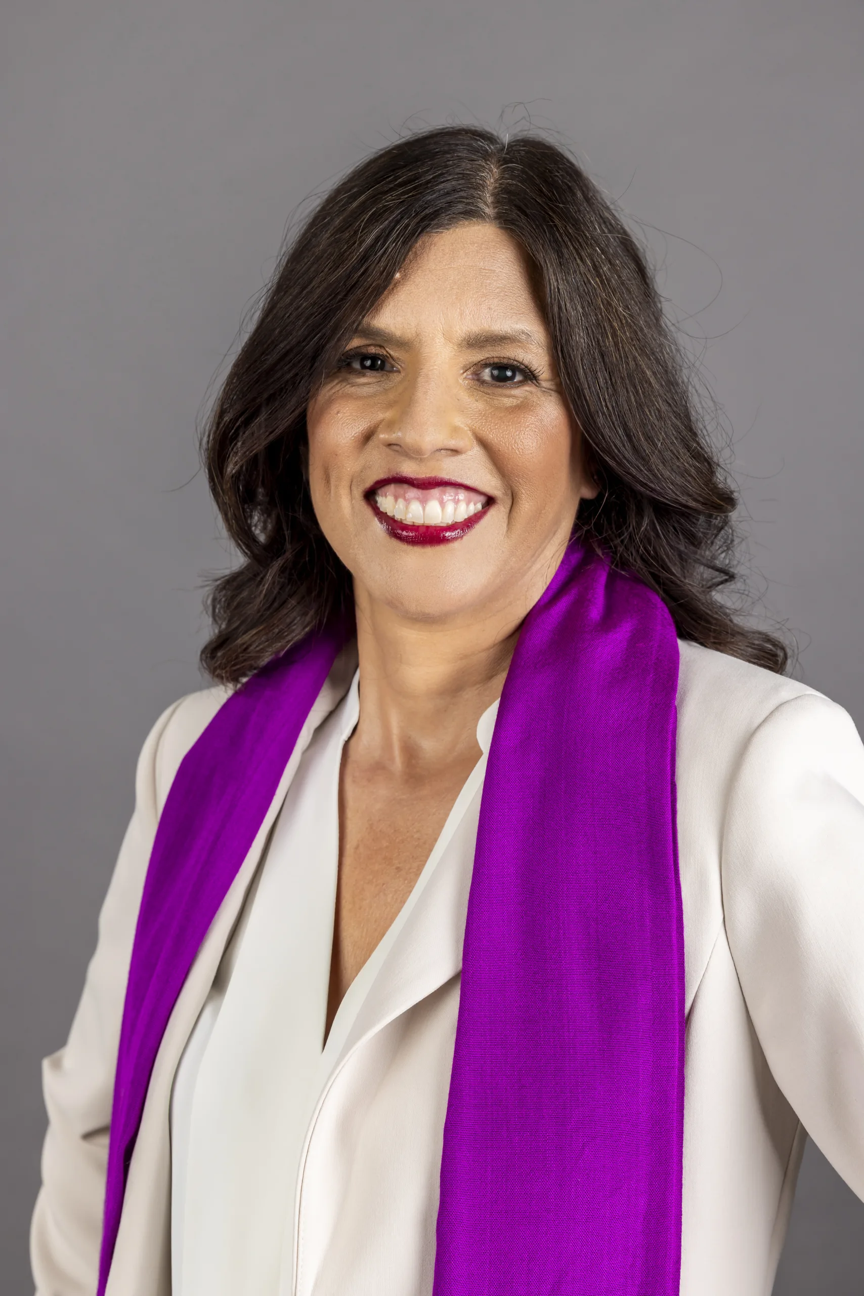 Photo of CFA President Margarita Berta Avila in a white with a purple scarf