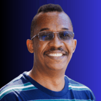 Photo of a man with glasses and in a blue striped shirt
