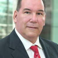 male candidate in black suit jacket and red tie