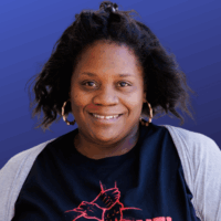 woman with dark hair and in black shirt smiles for photo