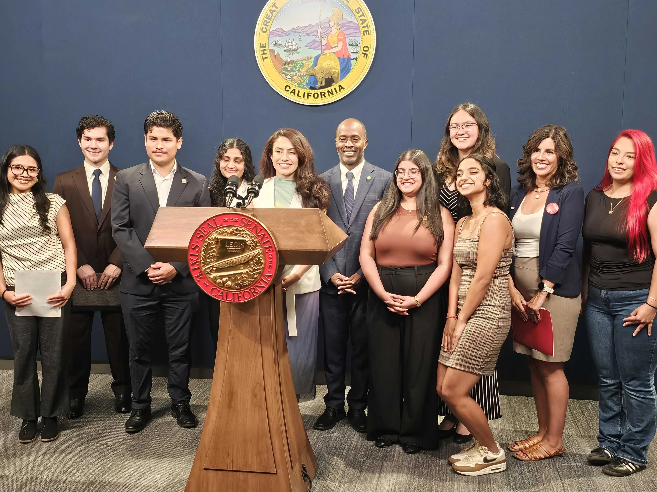 a group of people at a podium with assembly members.