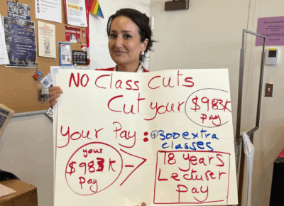 A person holds up a large sign.