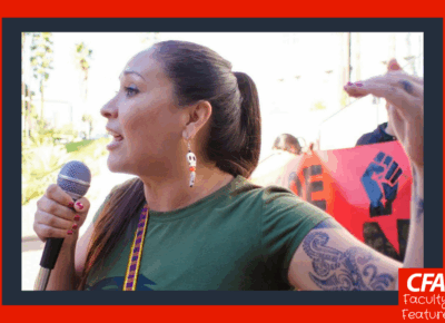 Person in a green tshirt and speaking into a microphone