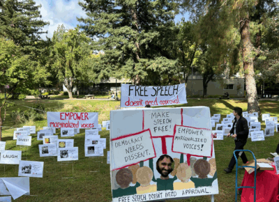 Lots of signs are displayed on a grass field.