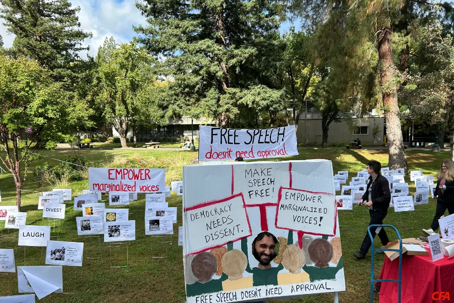 Lots of signs are displayed on a grass field.