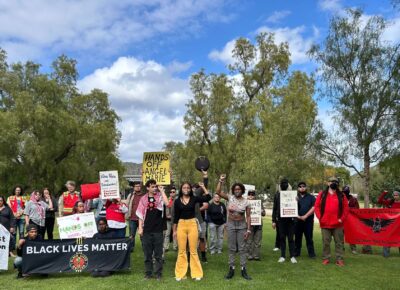A large group of students standing outside with duct tape on their mouths