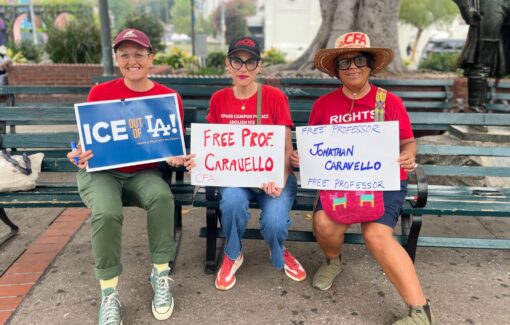 Three people sitting on a bench with signs