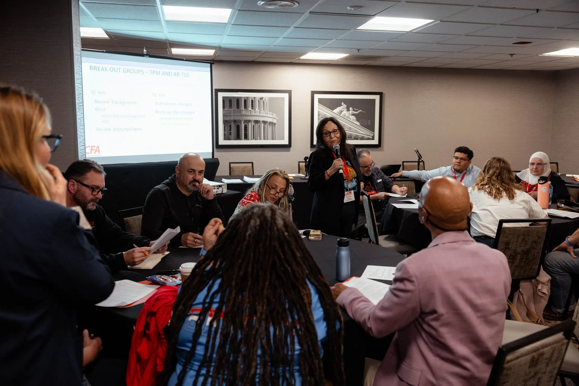 CFA members in a room. One speaker with microphone addresses members