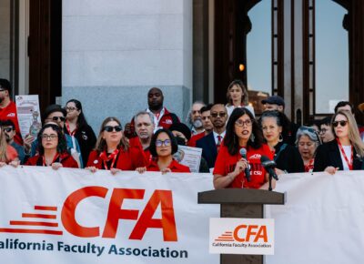CFA President speaking at the state capital while members stand behind her with a CFA banner