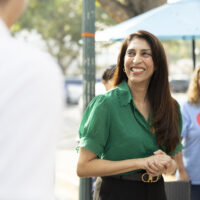 candidate in green shirt with hands folded