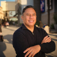 candidate in black shirt with arms folded