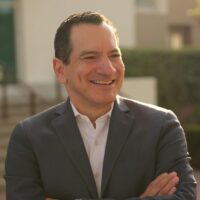 candidate in grey suit with arms crossed