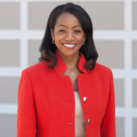 State Controller in red suit jacket